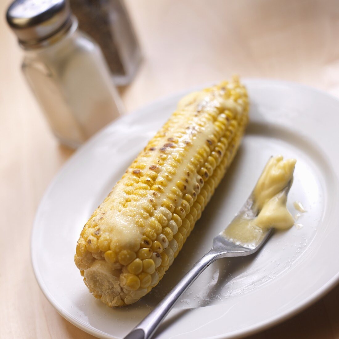 Roasted Corn Cob with Melted Butter; Fork