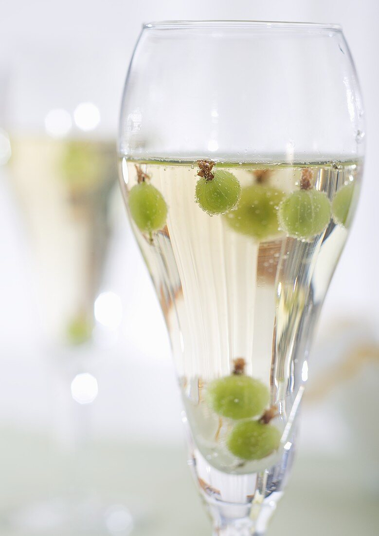 Glas Prosecco mit Stachelbeeren