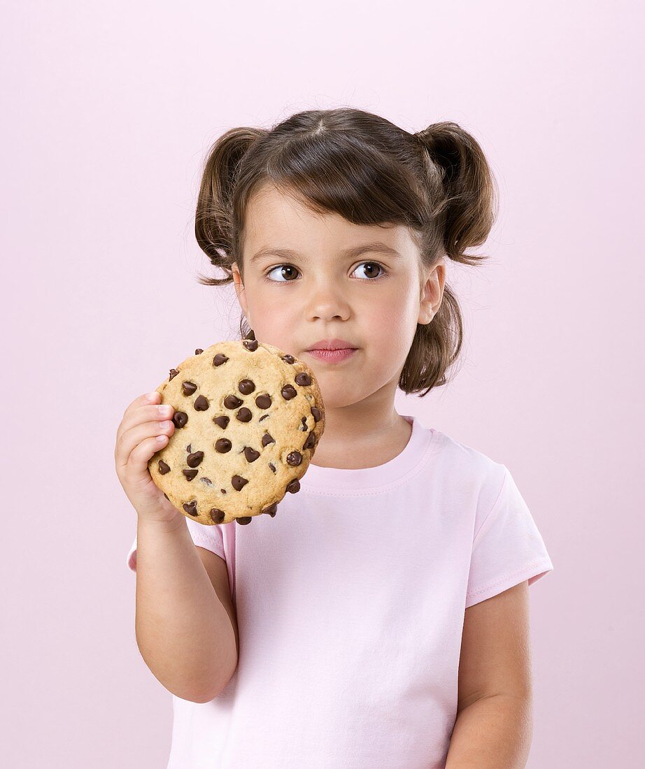 Kleines Mädchen hält einen chocolate chip cookie