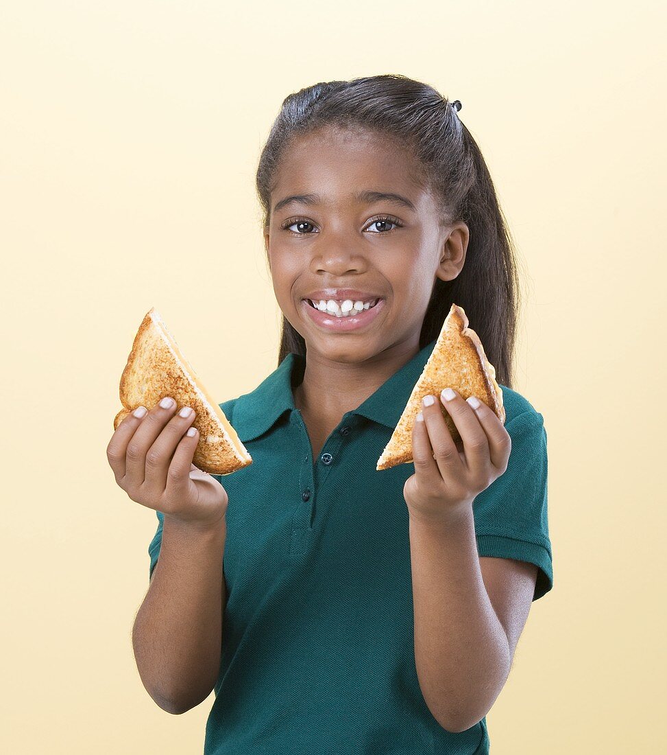 Mädchen hält ein gegrilltes Käsesandwich in den Händen