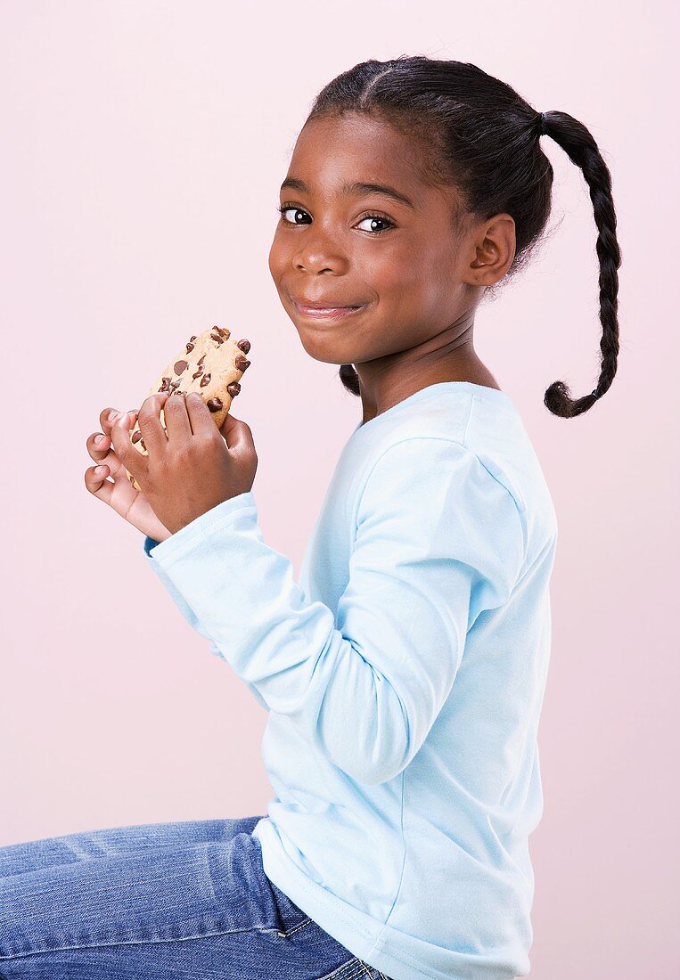 Mädchen hält angebissenen chocolate chip cookie in den Händen