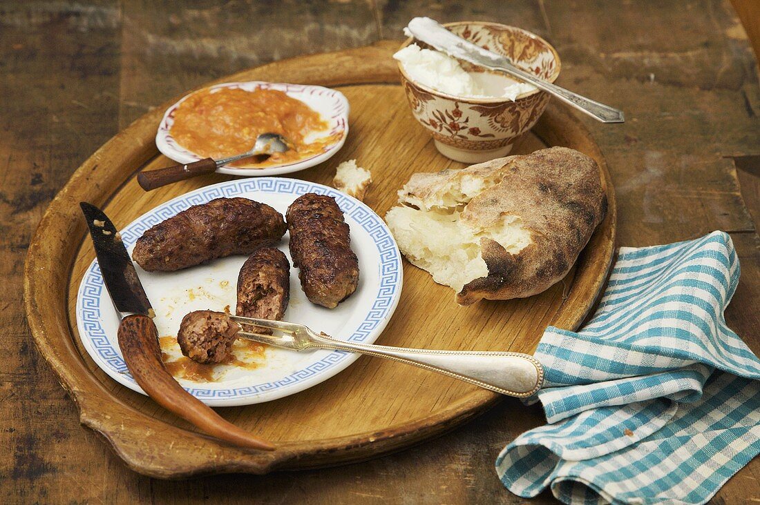 Cevapcici, Brot und Dips auf Holzteller