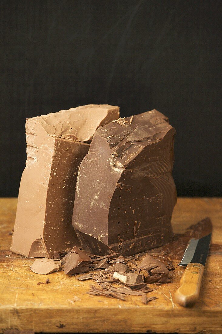 Schokoladenstücke auf Schneidebrett mit Messer