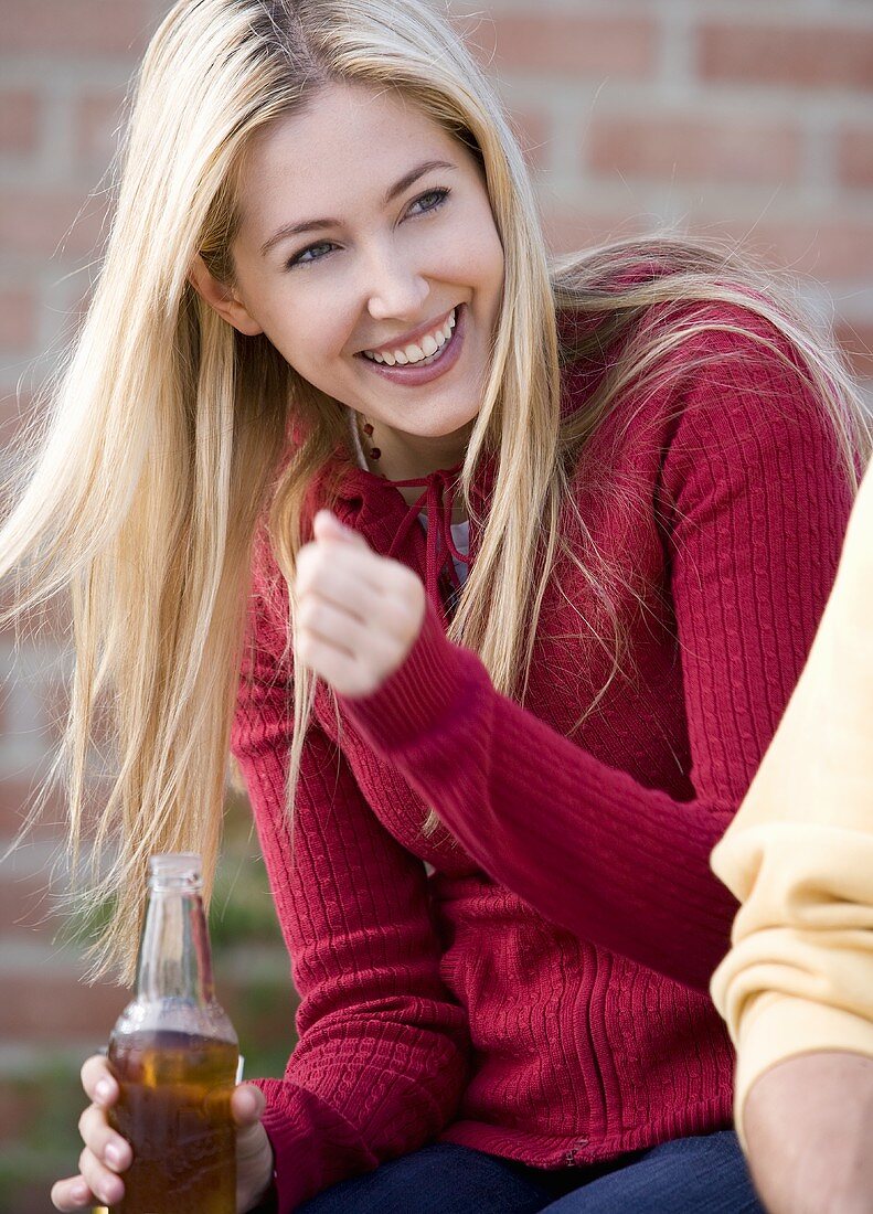 Junge Frau mit einer Flasche Bier in der Hand