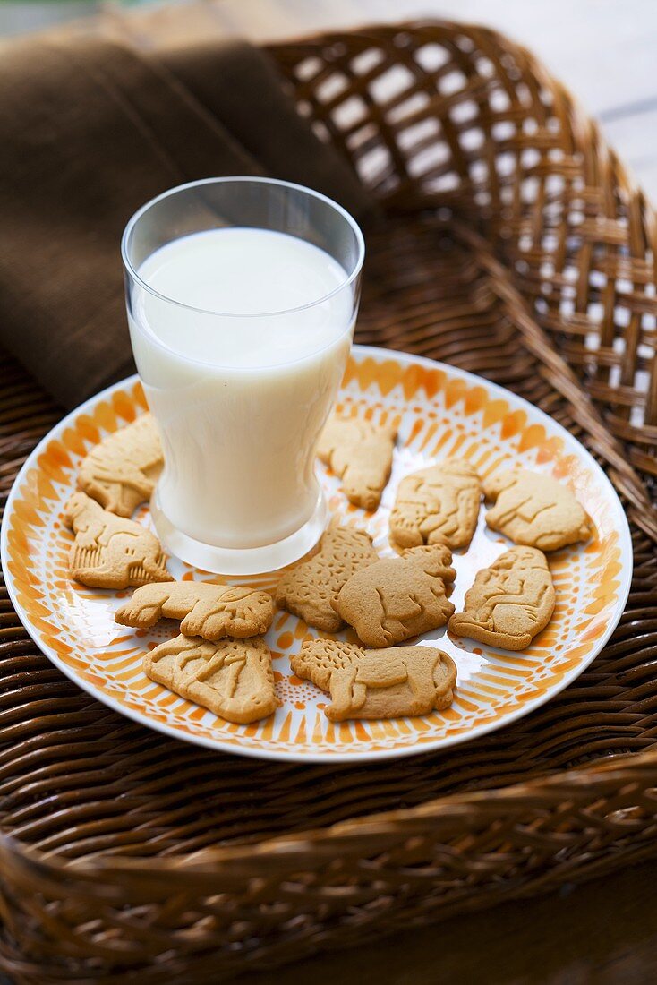 Ein Glas Milch mit Butterkeksen in Tierform