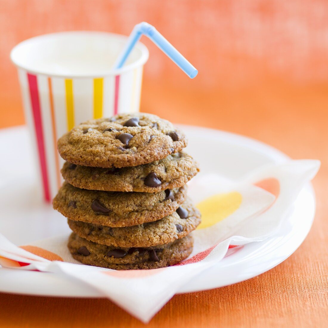 Stack of Chocolate Chip Cookies with a Cup of Milk with a Straw