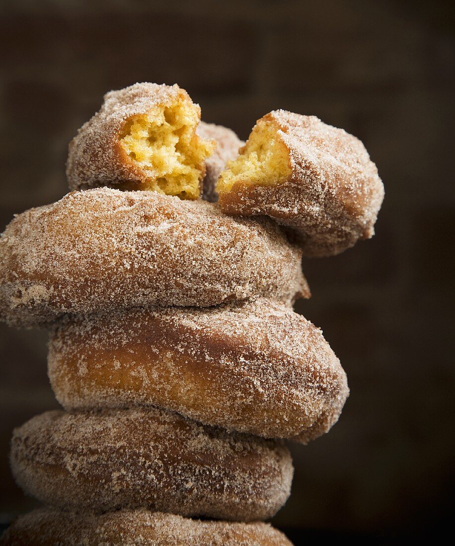 Stacked Homemade Sugar Doughnuts; Top One Broken