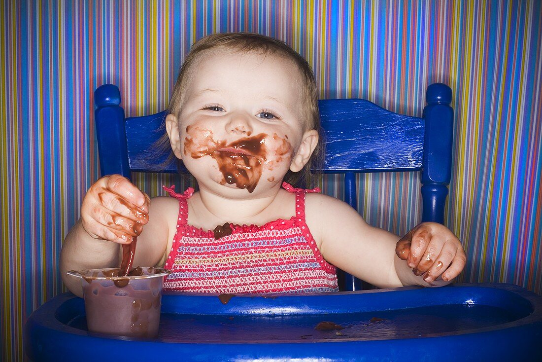 Baby isst Schokoladenpudding