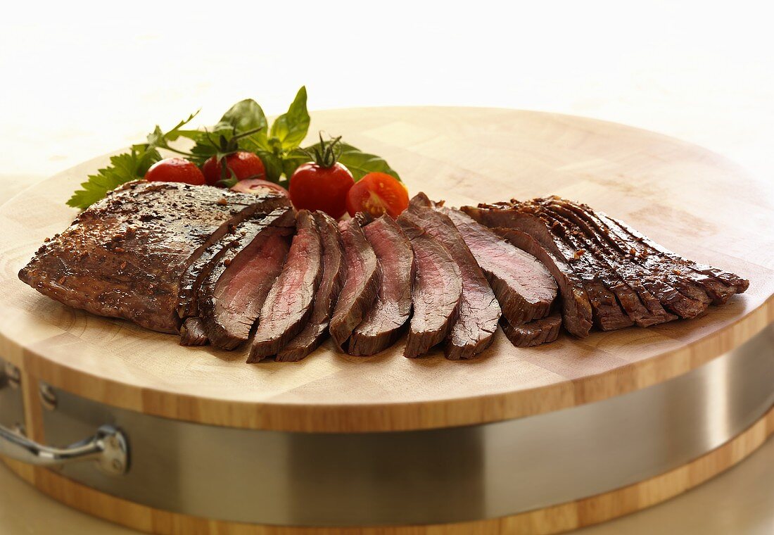 Sliced Flank Steak on a Wooden Board 