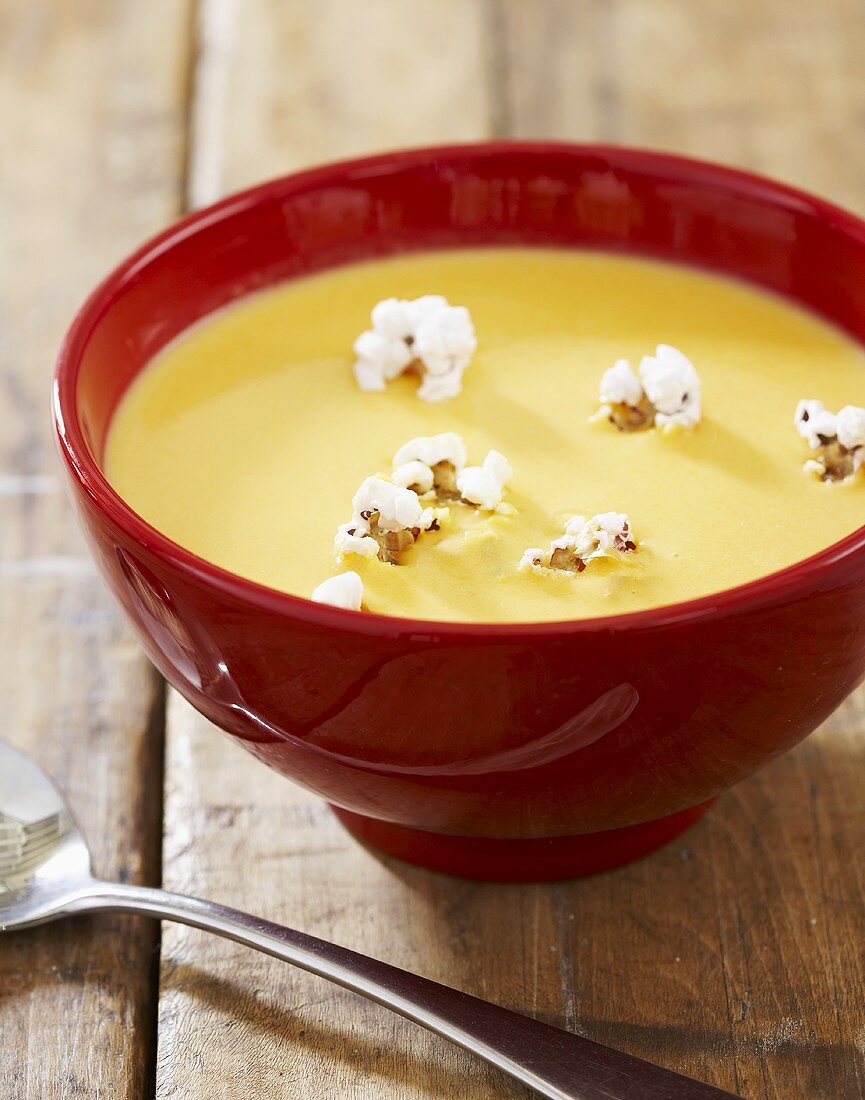 Bowl of Cheddar Cheese Beer Soup with Popcorn Garnish