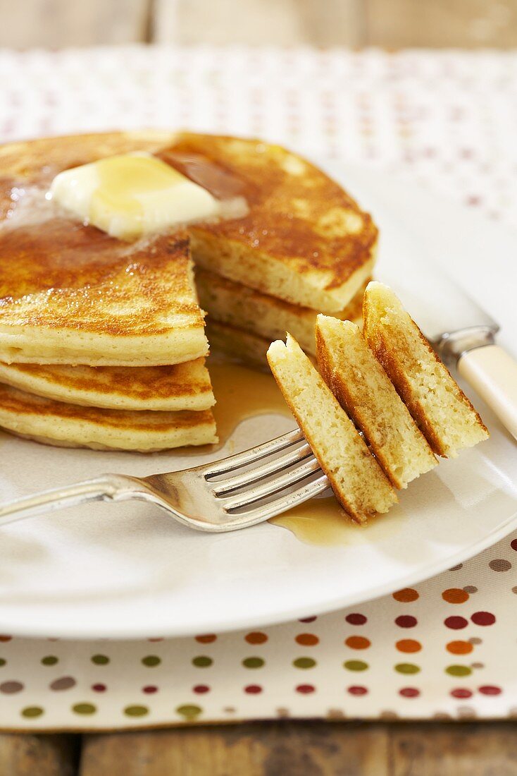 Stack of Pancakes with Butter and Syrup; Sliced with Fork