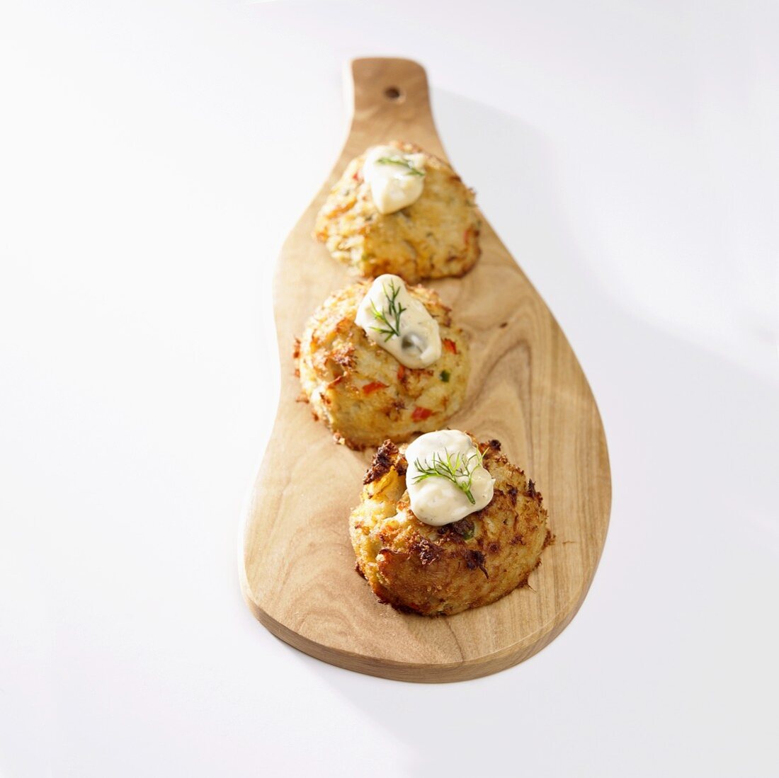 Crabcakes with Tartar Sauce and Dill on Cutting Board