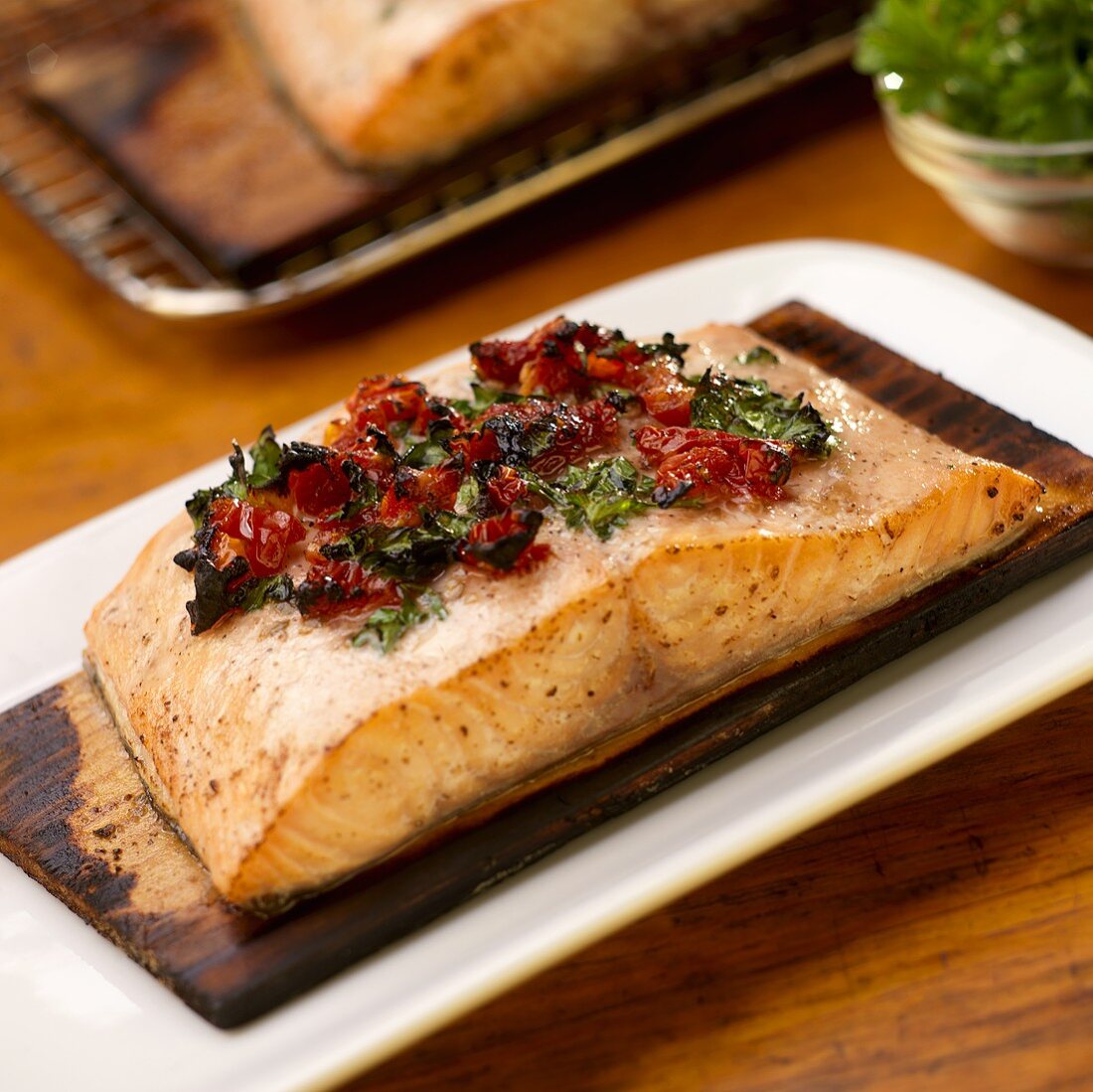 Gebratenes Lachsfilet mit getrockneten Tomaten auf Zedernholz