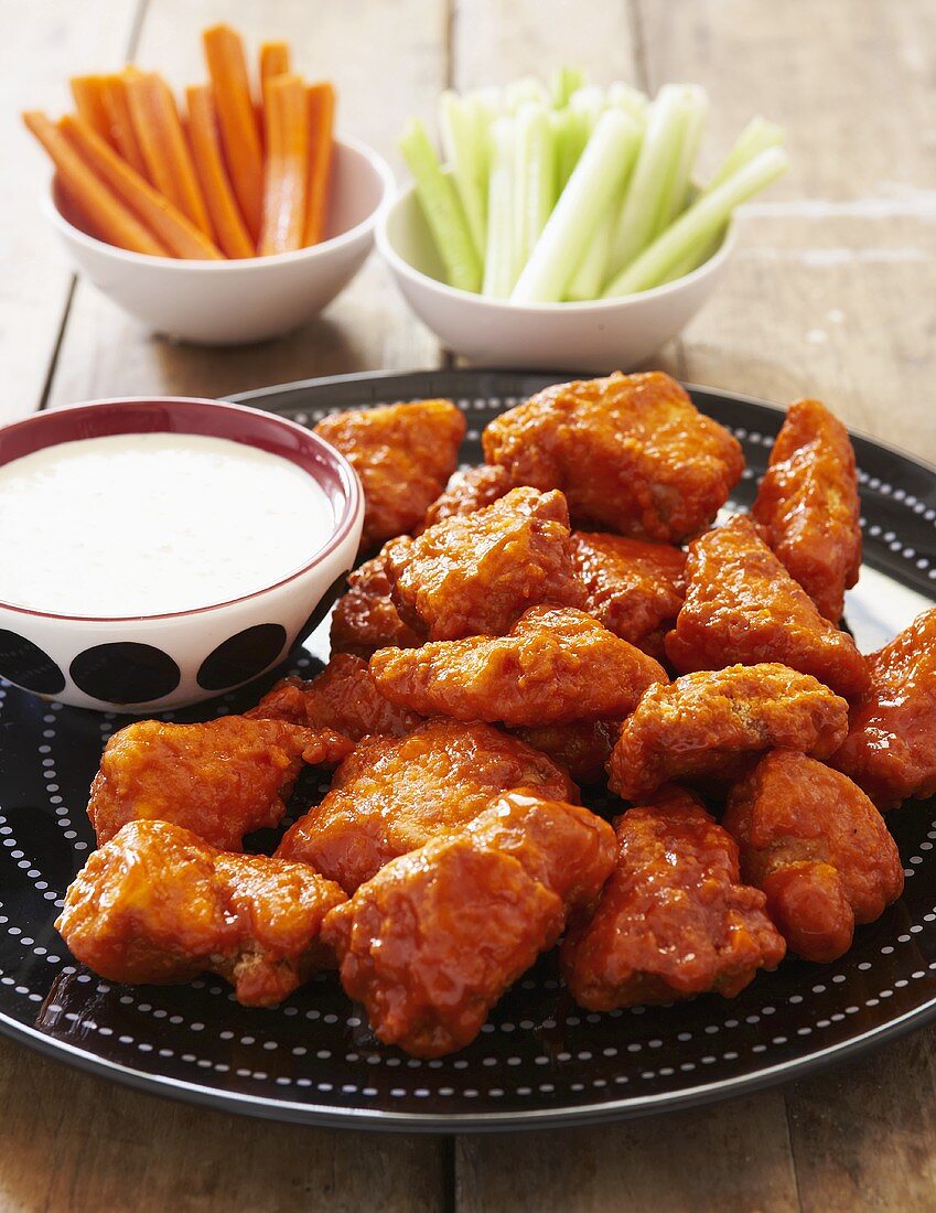 Boneless Buffalo Wings on a Platter; Dressing, Celery and Carrot Sticks