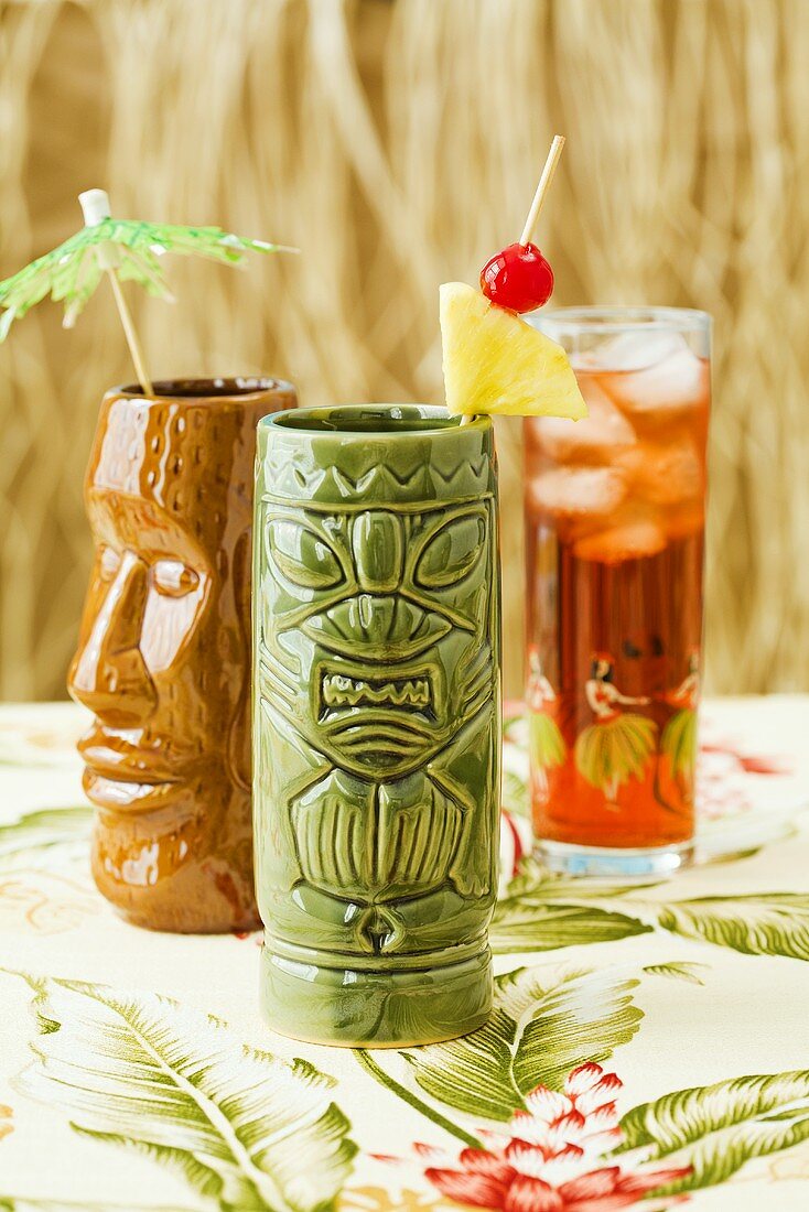 Cocktails in Two Tiki Glass with Fruit Cocktail in a Glass