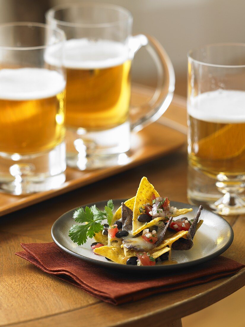 Plate of Nachos with Mugs of Beer
