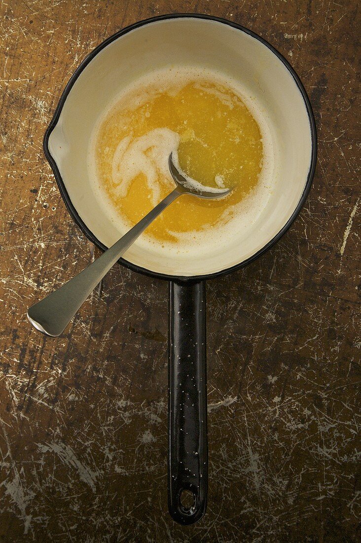 Melted Butter in a Pan; Spoon; From Above