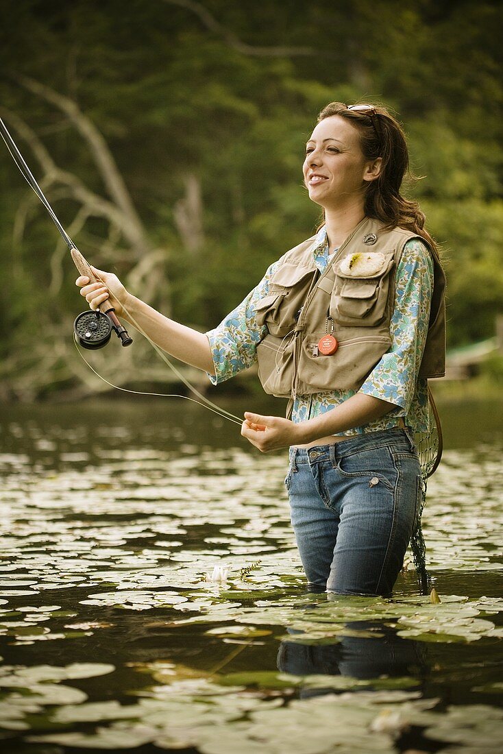 https://media02.stockfood.com/largepreviews/MjEzMTI4NDE=/00687511-Woman-Fly-Fishing-in-River.jpg