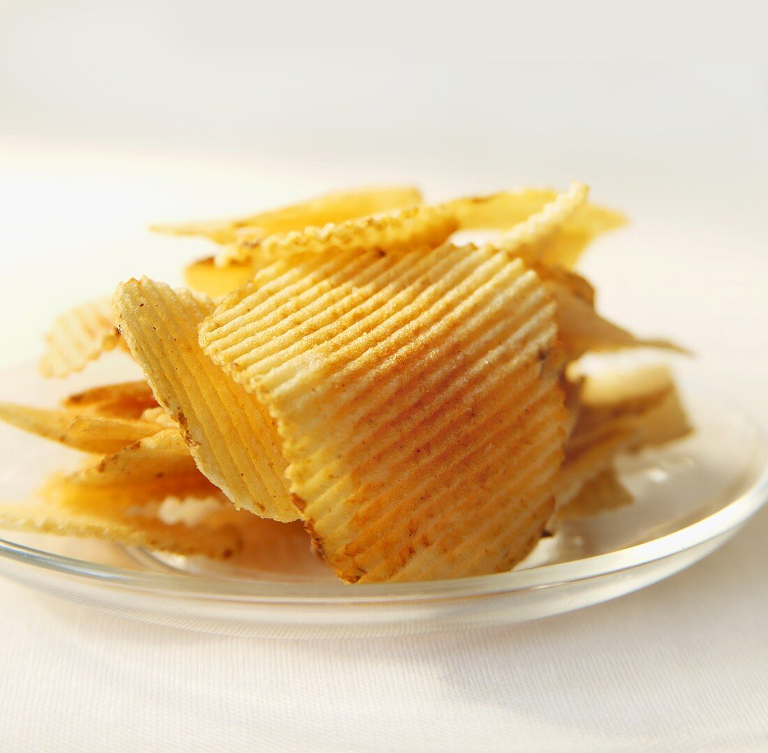 Geriffelte Kartoffelchips auf Glasteller