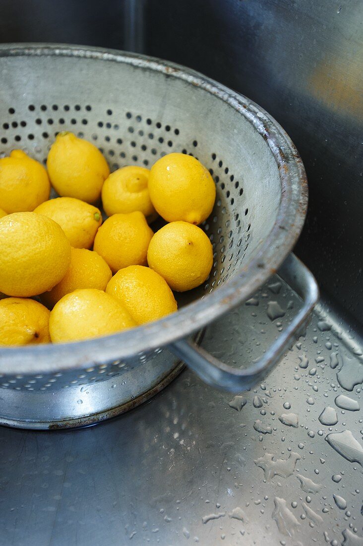 Lemons in Colander in Stainless Steel Sink