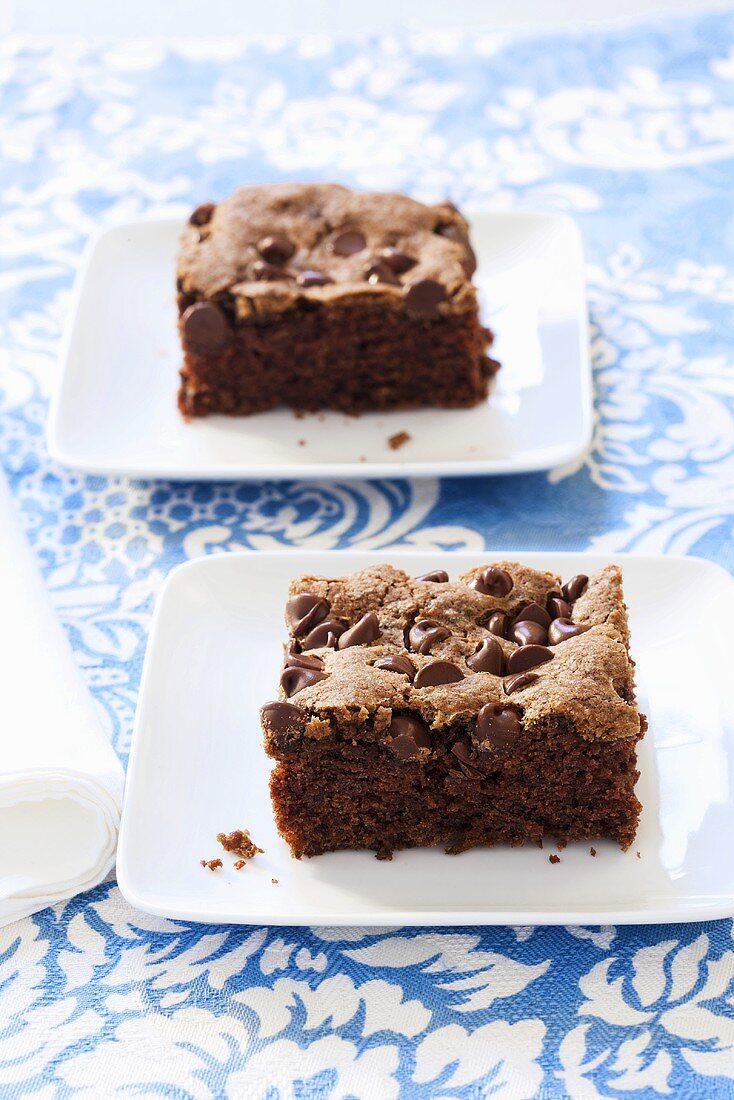 Two Pieces of Chocolate Zucchini Cake on White Plates
