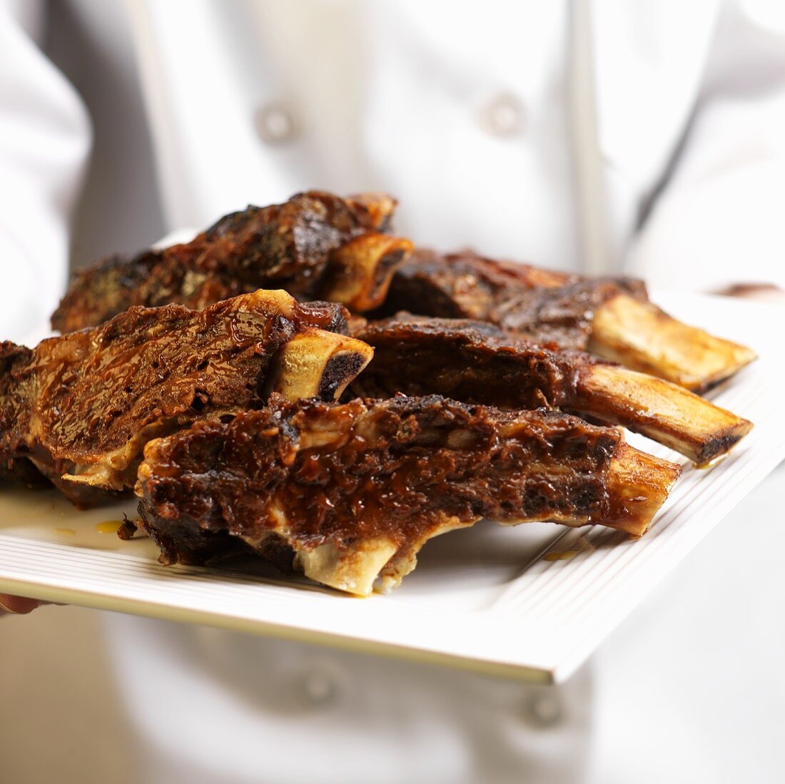 Person Holding Plate of Beef Ribs