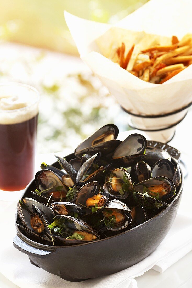 Gedämpfte Muscheln mit Pommes frites und dunklem Bier