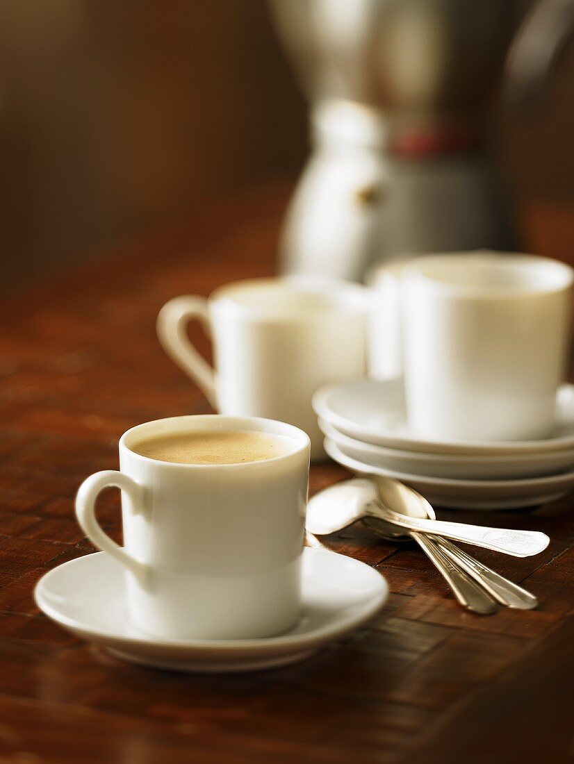Cup of Cuban Coffee in White Mug on Sauce; Spoons and Mugs