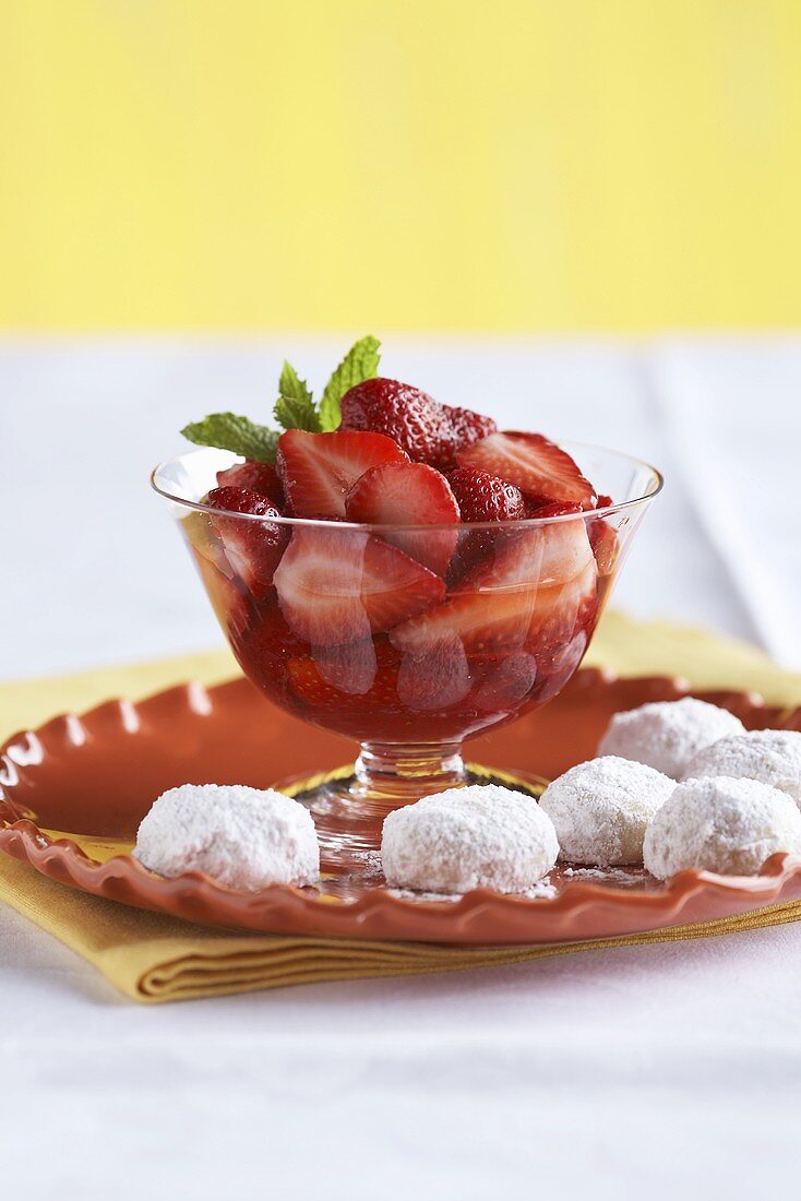 Erdbeeren in Sirup und Plätzchen mit Puderzucker