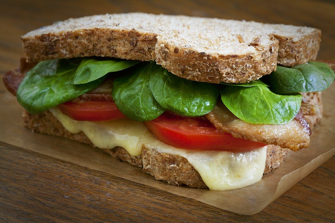 Bacon, Tomato and Spinach Sandwich with Melted Cheese on Whole Wheat Bread