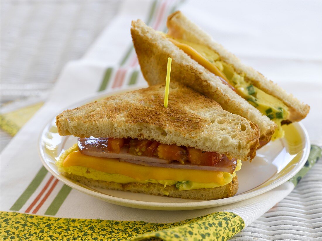 Getoastete Sandwiches mit Ei, Käse, Schinken und Tomate