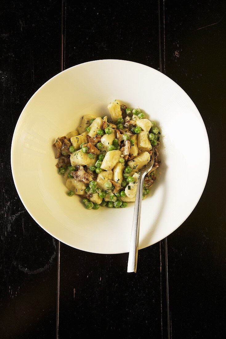 Truffled Gnocchi with Peas and Chanterelles in a White Bowl