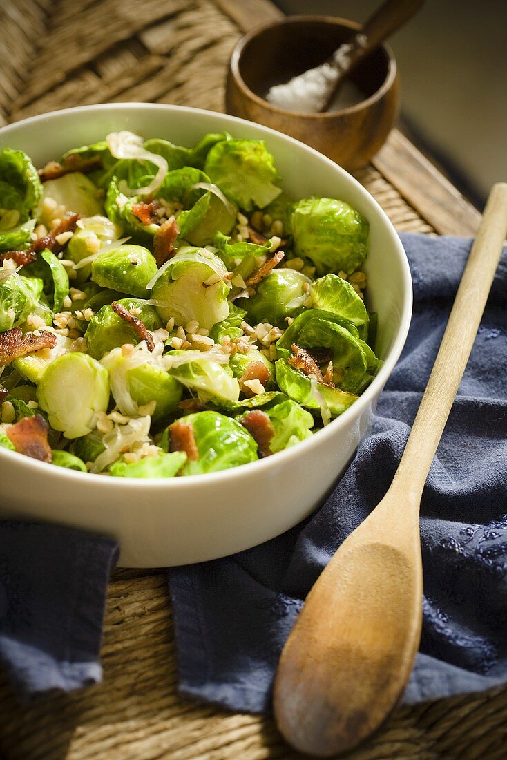Bowl of Brussels Sprouts with Bacon and Walnuts; Wooden Spoon