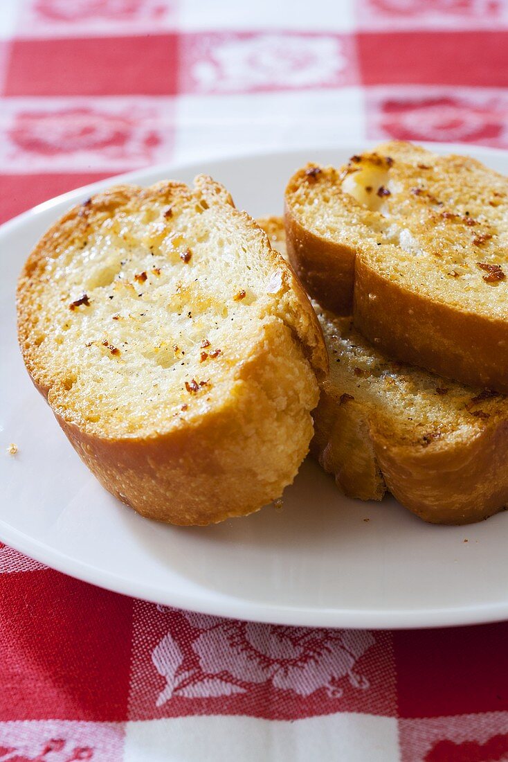 Getoastete Knoblauchbrotscheiben auf Teller