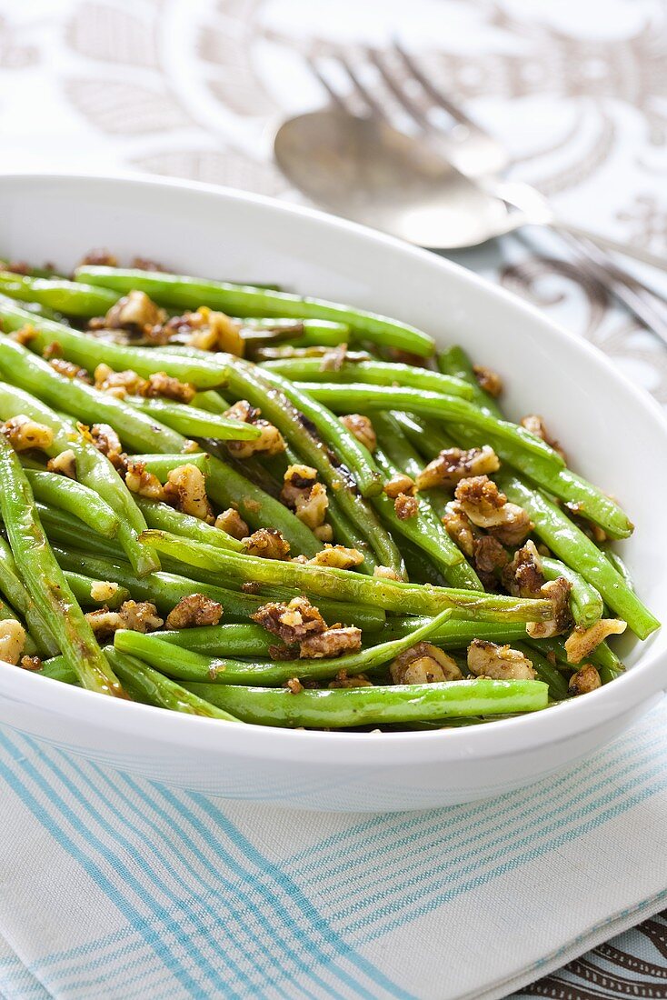 Green beans with spicy nuts in serving dish