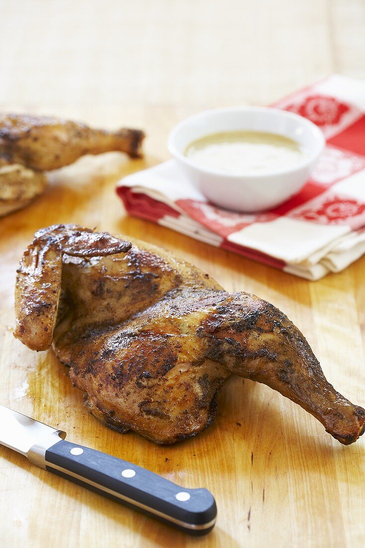 Roasted Half Chicken on Cutting Board; Knife