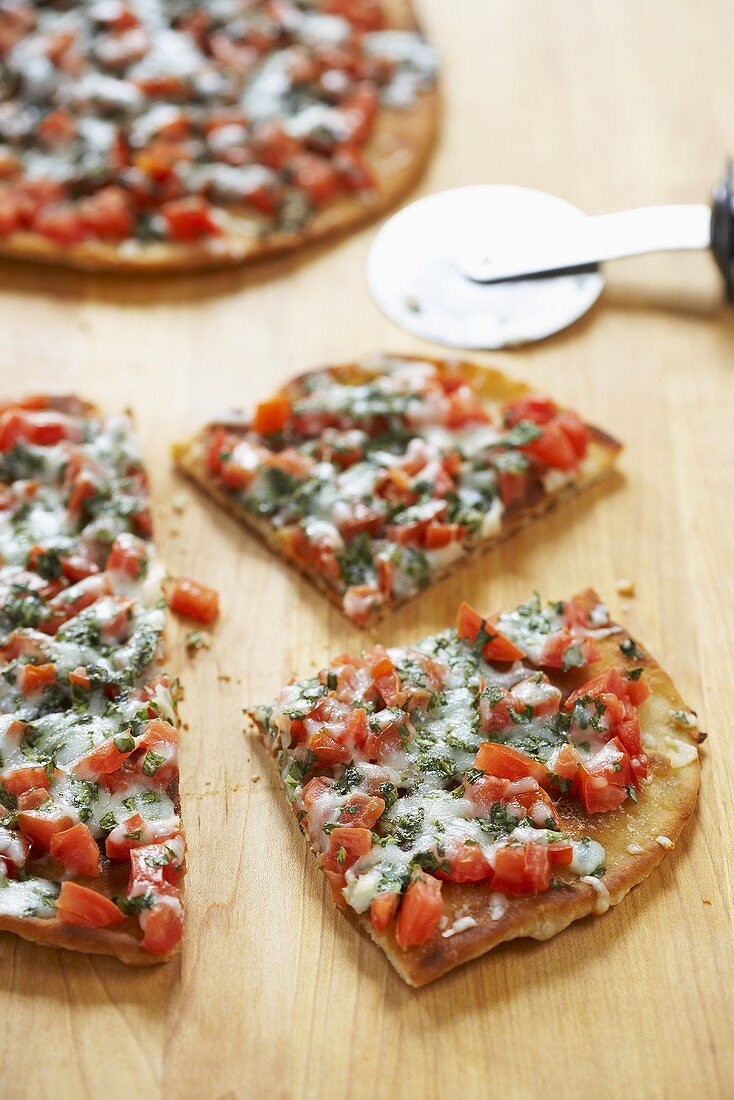 Zwei Pizzen mit Basilikum, Tomaten und Käse