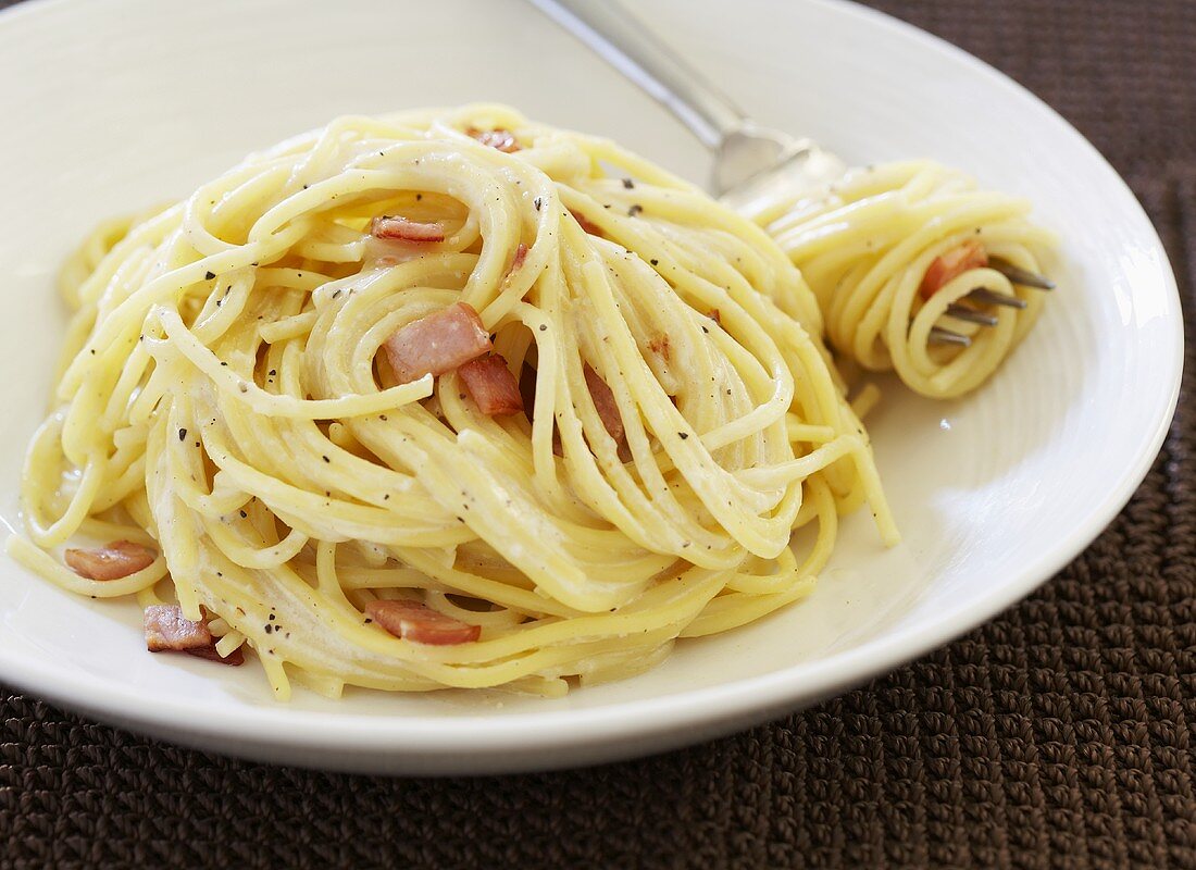 Spaghetti Carbonara in White Bowl; Twirled on Fork