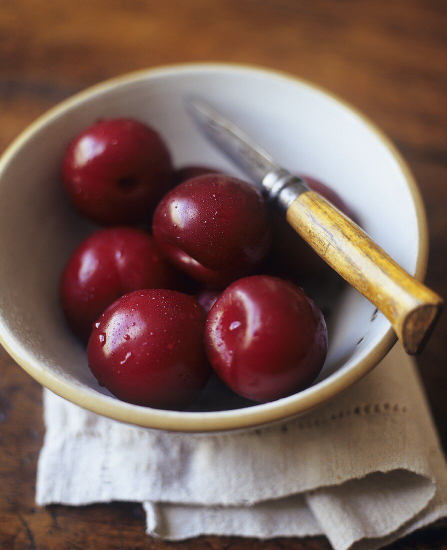 Freshly Washed Plums in a Bowl with Knife