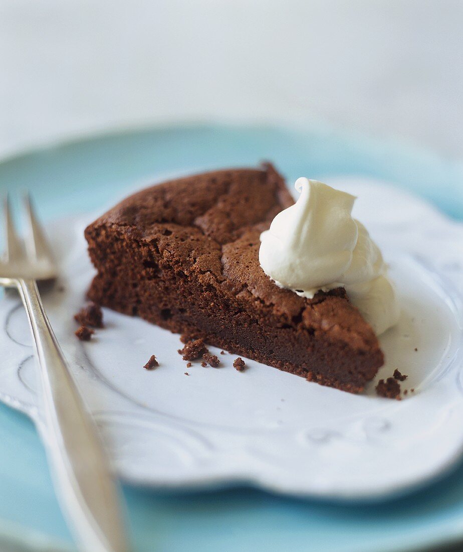 Ein Stück Schokoladenkuchen mit Sahneklecks