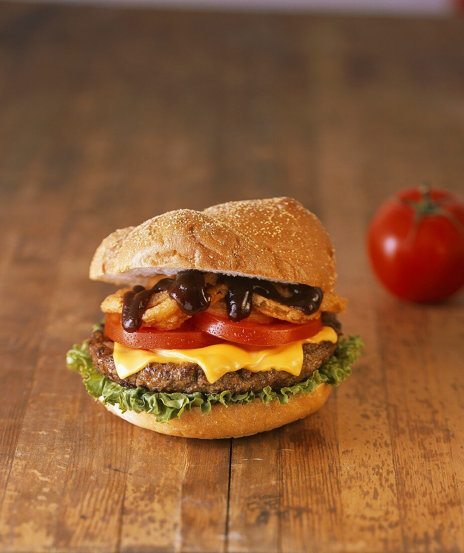 Cheeseburger mit Tomaten und frittierten Zwiebelringen