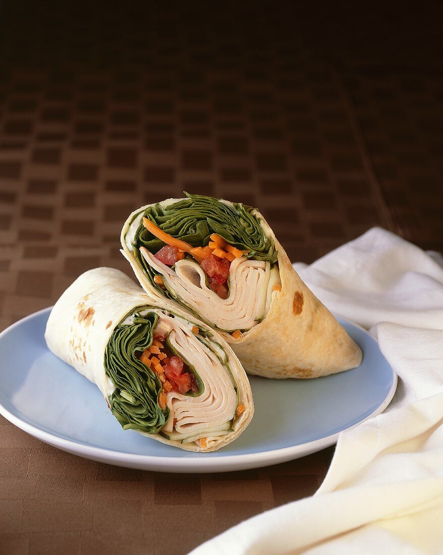 Turkey and Spinach Wrap; Halved on Blue Plate