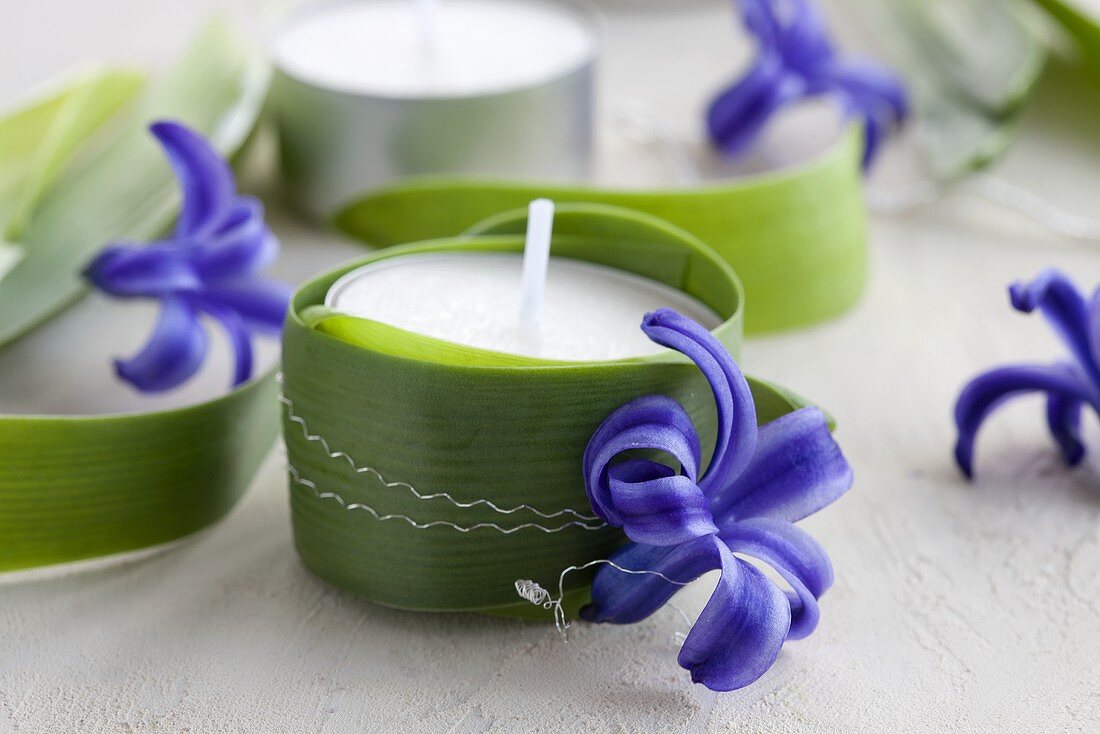 Tealights wrapped with leaves and decorated with hyacinth flowers