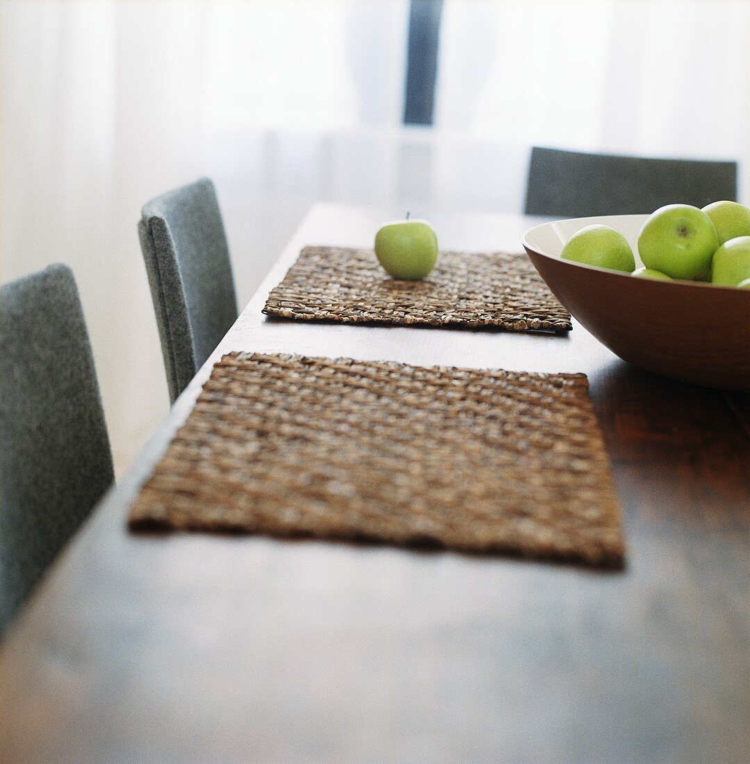 A bowl of apples on a dining table