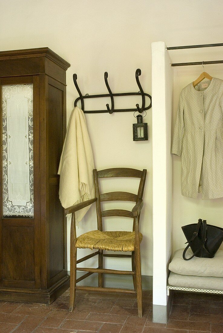 A chair, coat hooks and a clothes rail in a hallway