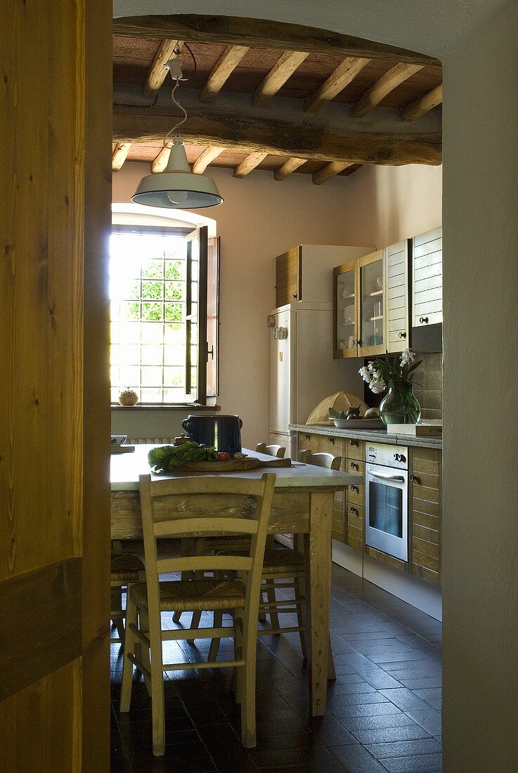Blick in eine Küche mit einem rustikalen Esstisch
