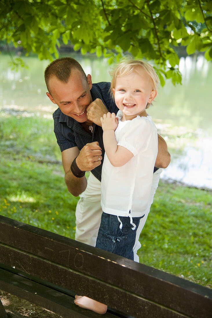 A father with his little daughter by a lake