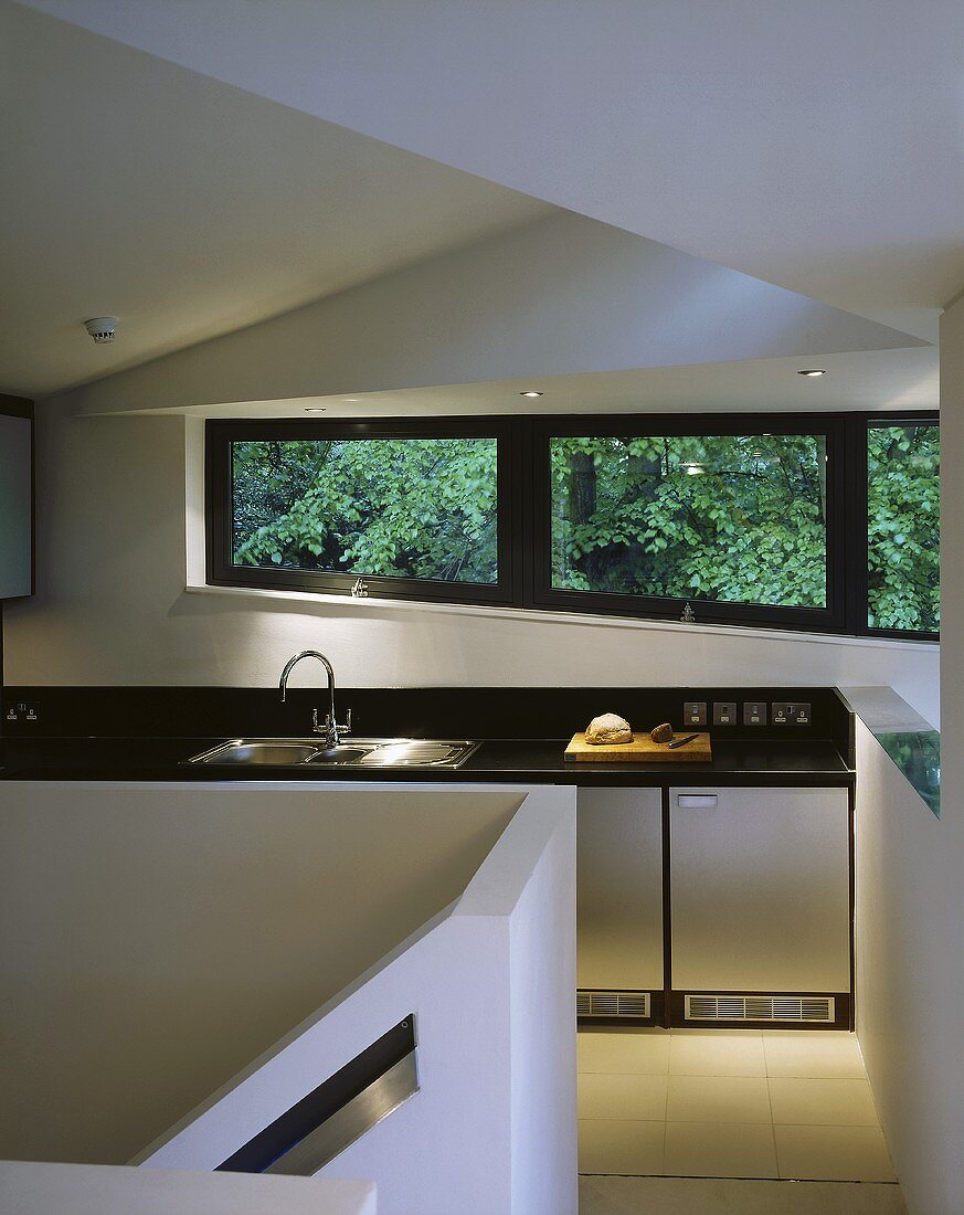 An open plan designer kitchen with windows looking onto trees