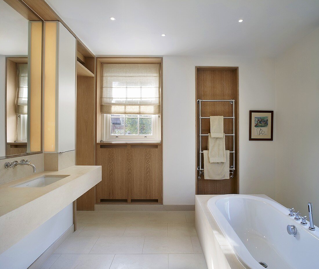 Spacious designer bath with a free standing bathtub and a narrow cubic countertop