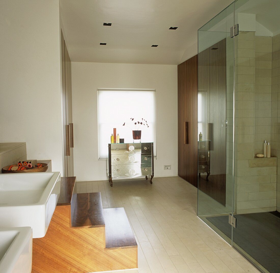A walk-in shower cubicle with glass doors in a modern bathroom